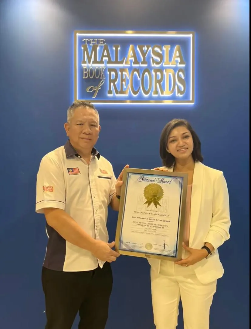 Mishantini Sanderasagran with the Malaysia Book of Records recognition for the most autism curriculum lessons by an individual